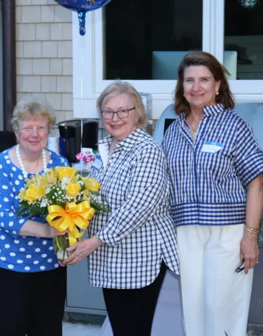 ARCS Ligth Recipient Mary Jo Ruane receiving a a bouget of flowers.